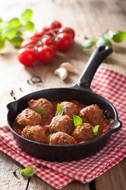 Fleischbällchen mit Tomatensauce in schwarzer Pfanne