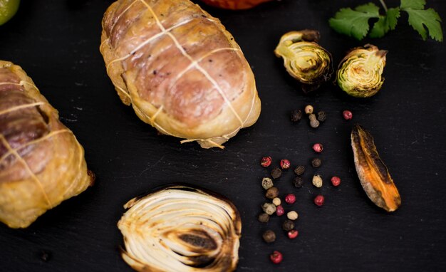 Fleischprodukte gegrillt und gegrilltes Gemüse auf dunklem Hintergrund