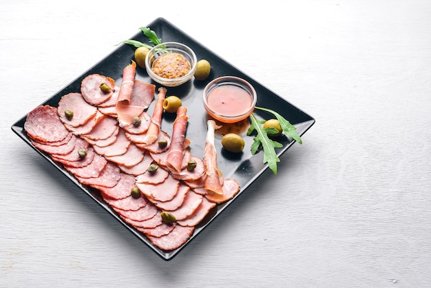 Fleischscheiben auf einem Teller mit Ketchup und Senf Wurst und Speck Auf einem hölzernen Hintergrund Ansicht von oben Freier Speicherplatz