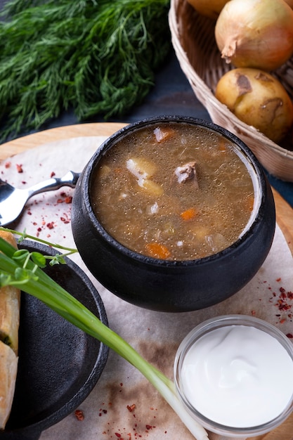 Fleischsuppe in einem Topf mit Pilzen und Gemüse.