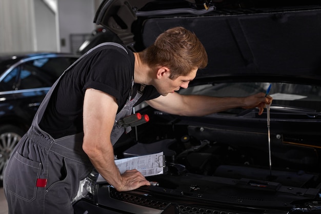 fleißiger Angestellter in Uniform arbeitet im Autosalon