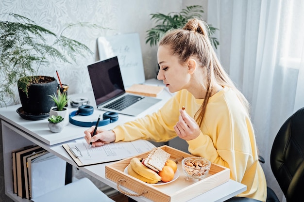 Flexibles Arbeiten Flexibles Arbeiten Freiberuflerin der jungen Frau, die zu Hause im Büro mit Laptop arbeitet und