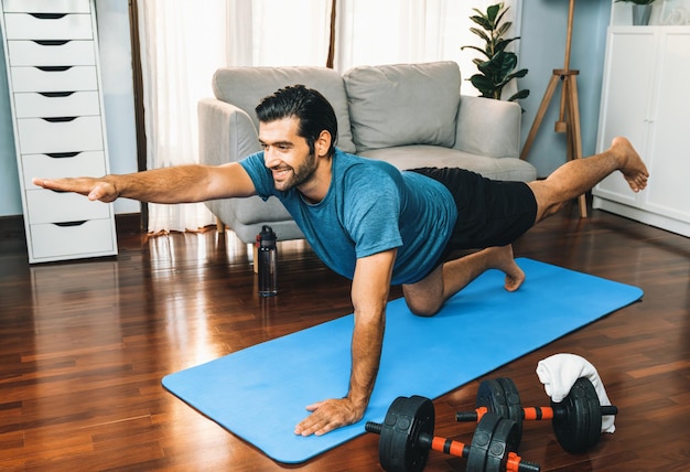 Flexível e destreza homem em roupas esportivas fazendo inversa alegria posição de ioga