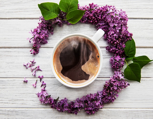 Fliederblumen und eine Tasse Kaffee