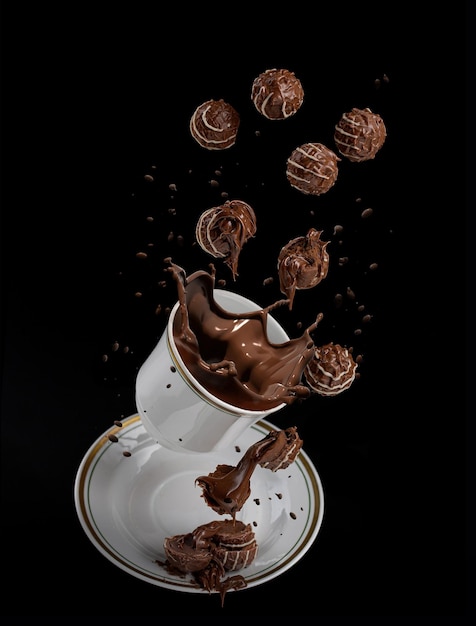 Fliegende Süßigkeiten mit weißem Zuckerguss und weicher Schokoladenfüllung auf einem weißen Teller auf schwarzem Hintergrund