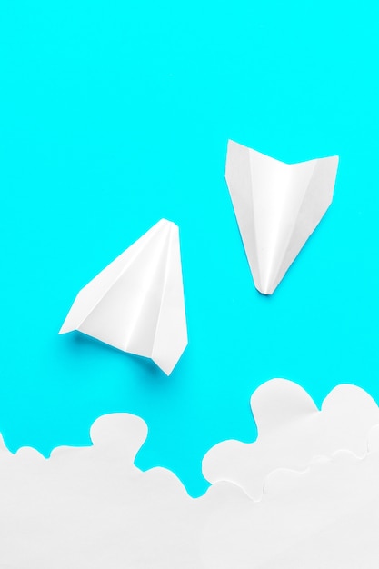 Fliegendes Papierflugzeug in den Wolken. Konzept von Flug, Reise, Transfer