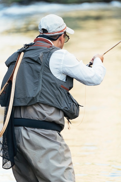 Fliegenfischer mit Fliegenfischerrute im schönen Fluss