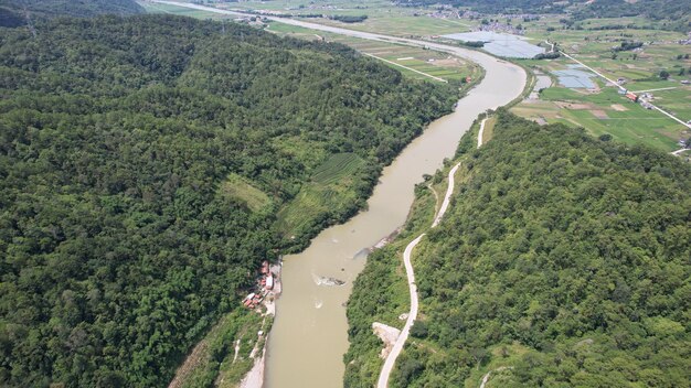 Foto fließende flüsse, rote häuser im hintergrund und hohe grüne bäume in den bergen