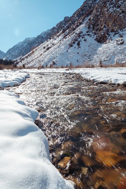 Fließender Gebirgsfluss im Winter