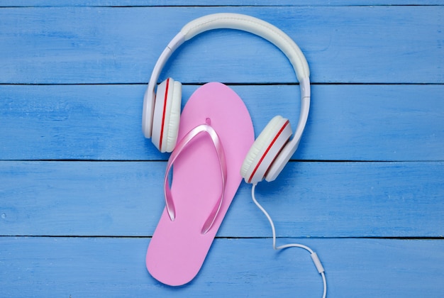 Flip flop y auriculares sobre fondo de madera azul