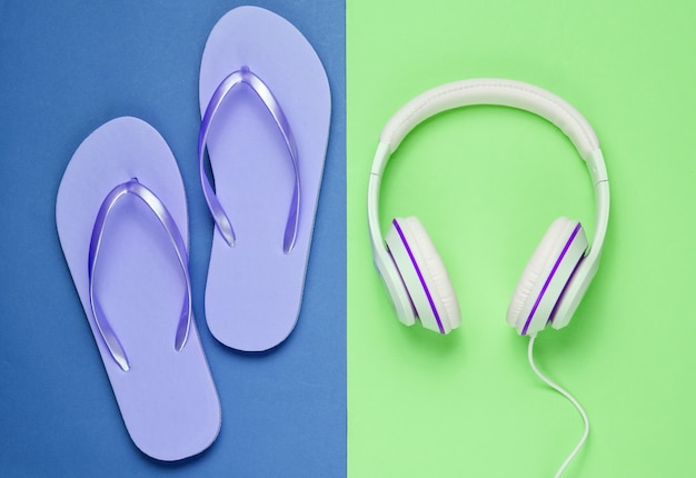 Flip-flop e fones de ouvido em fundo colorido