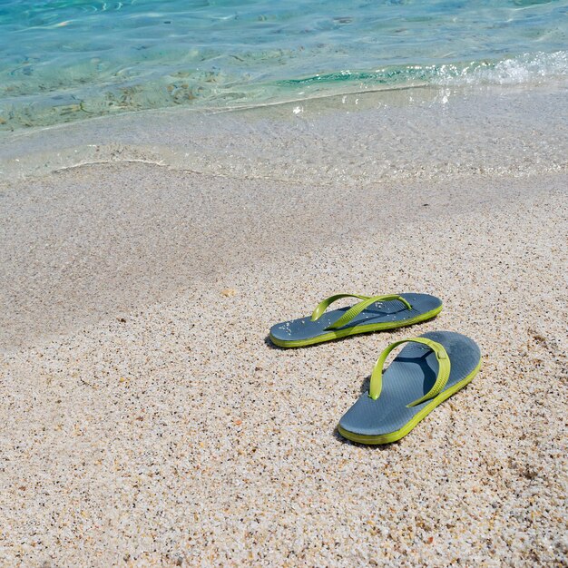 Flip Flops am Küstenvorland mit türkisfarbenem Wasser