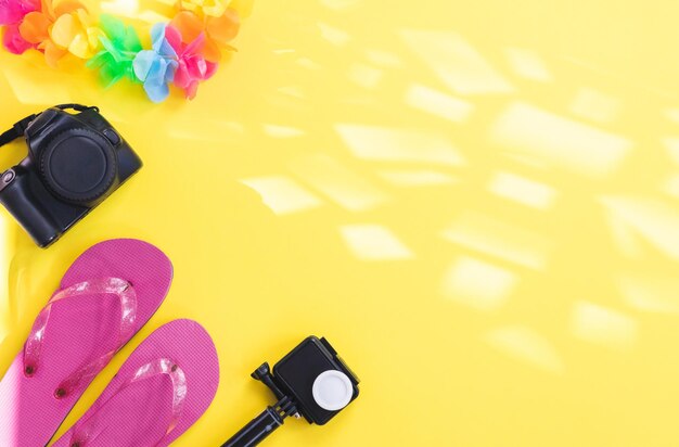 Flip-Flops mit zwei Kameras und ein mexikanisches Accessoire auf gelbem Hintergrund