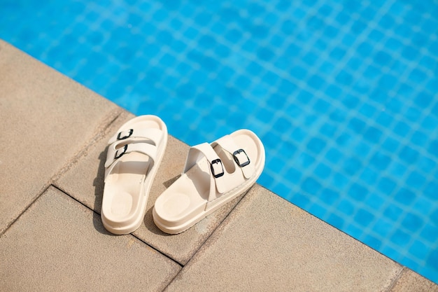 Flip-flops na borda da piscina