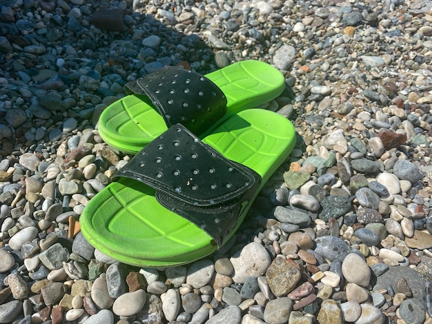 Foto flipflops am farbigen kiesstrand sommer- und urlaubskonzept