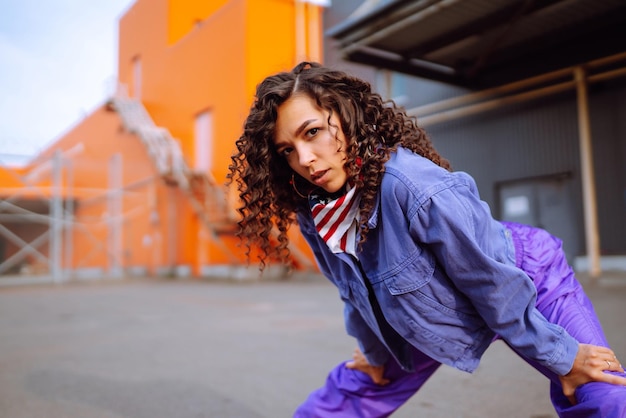 Flippige junge Frau mit amerikanischem Kopftuch tanzt allein im StreetSport-Tanzen und in der urbanen Kultur