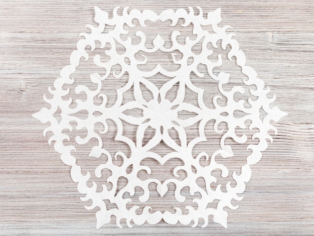 Foto floco de neve de papel na mesa de madeira marrom clara