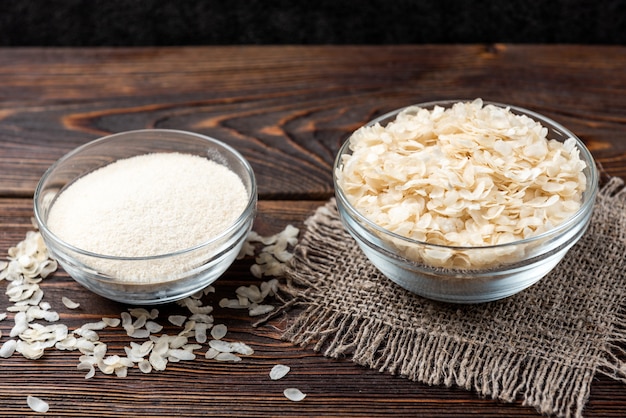 Flocos de arroz e farinha em madeira escura