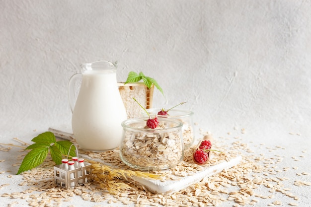 Flocos de aveia, leite e rasberry em uma mesa. alimentação e bebidas saudáveis e vegetarianas à base de plantas. foco seletivo, close-up