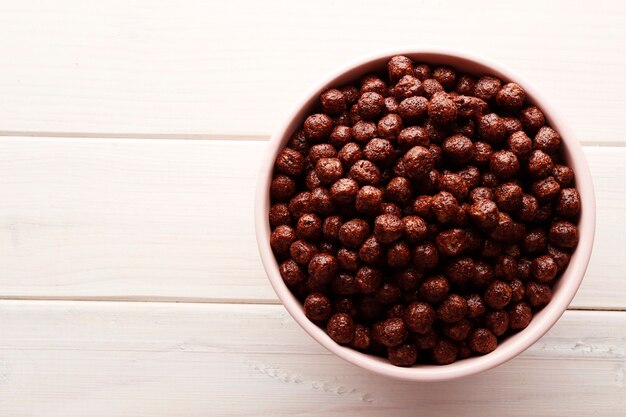 Flocos de chocolate em um fundo branco de madeira