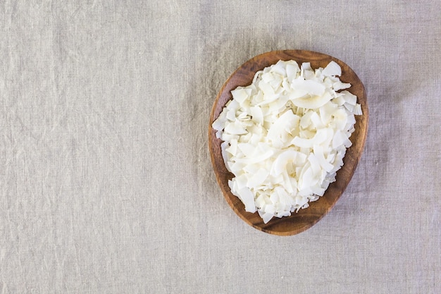 Flocos de coco desidratado em uma tigela de madeira.