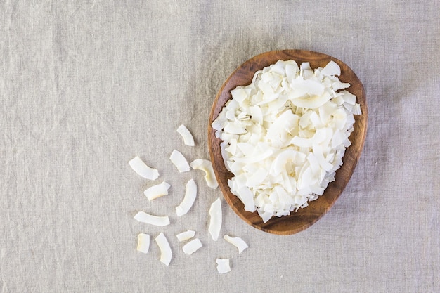 Flocos de coco desidratado em uma tigela de madeira.