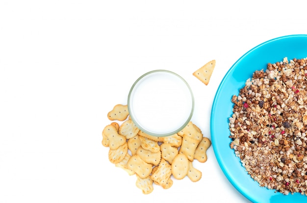 Flocos de muesli em chapa azul, biscoitos e copo de leite