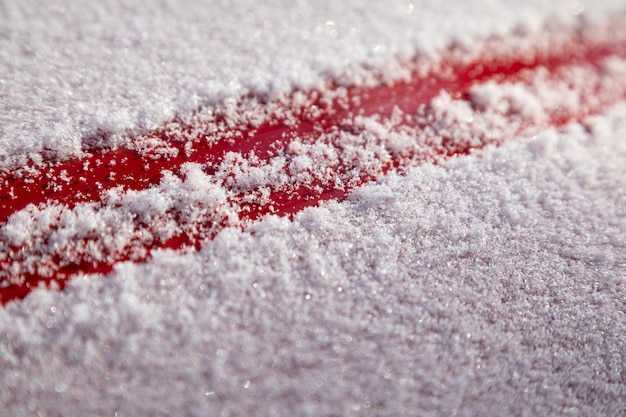 Flocos de neve fofos no fundo de metal vermelho. o conceito da primeira neve