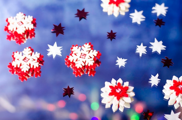 Foto flocos de nieve de navidad y pequeñas estrellas sobre un fondo azul