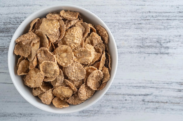 Flocos vitrificados de grãos inteiros no prato Café da manhã saudável muesli de grãos integrais em uma tigela