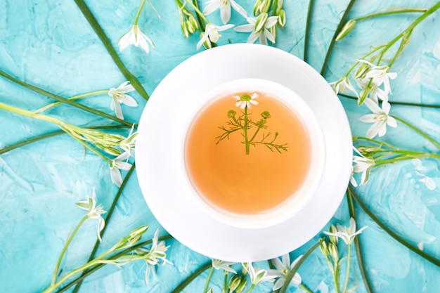 Foto flor alrededor de una taza de té de manzanilla