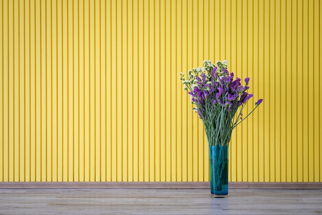 Flor amarela e roxa em vaso em fundo amarelo