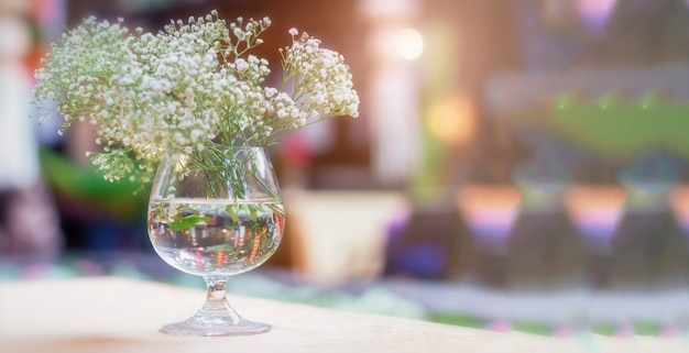 Foto flor blanca en vidrio en la mesa de la cena