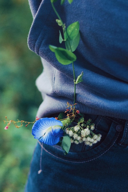 Foto una flor en el bolsillo trasero de los jeans de una persona