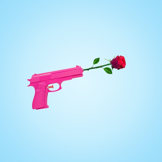 Flor color de rosa con pistola rosa sobre fondo azul.