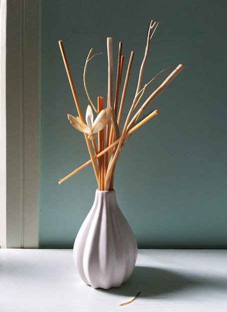 Flor com pauzinhos em vaso na mesa