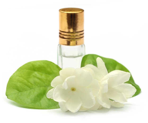 Flor de jasmim com frasco de essência sobre fundo branco