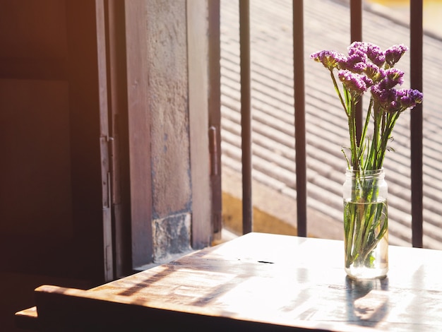 Foto flor de lavanda em vaso de vidro perto da janela