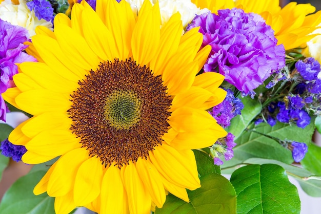 flor decorativa de um girassol closeup com pétalas amarelas brilhantes em um buquê com outras flores