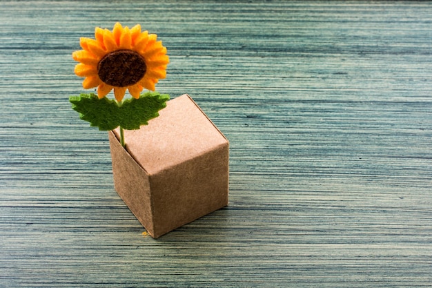 Flor falsa anexada a um cubo de caixa de papel