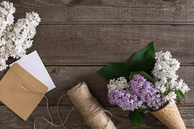 Flor lila sobre fondo de madera rústica con espacio vacío para mensaje de saludo tijeras carrete de hilo ...