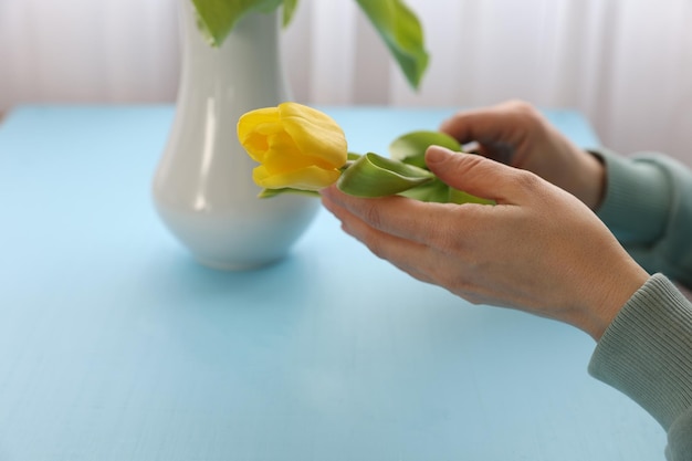 Flor en mano junto a un jarrón