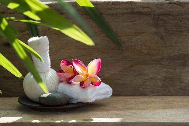 Foto flor de plumeria y productos de aromaterapia spa bola de masaje en madera