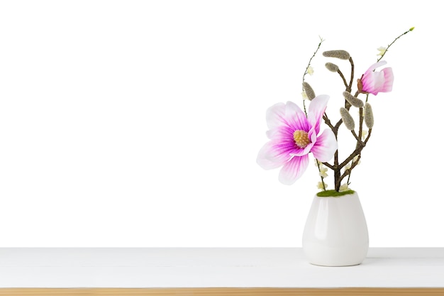 Flor rosa decorativa em um vaso no fundo branco isolado na mesa