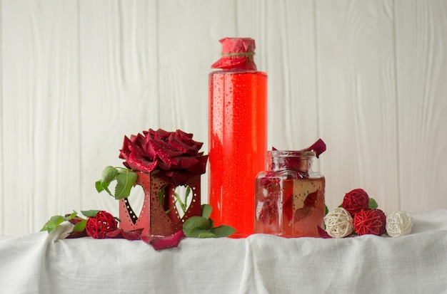 Flor de rosa rosa y vaso de agua de rosas Agua de rosas orgánica fresca Agua de rosas en botella de vidrio