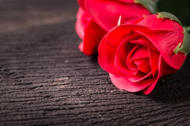 flor de rosas de amor rojo en la mesa de madera de grunge de cerca.