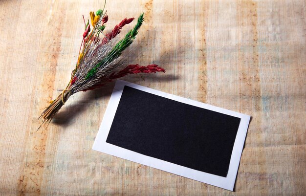 Flor seca con cuaderno en blanco sobre mesa de madera antigua Tono vintage