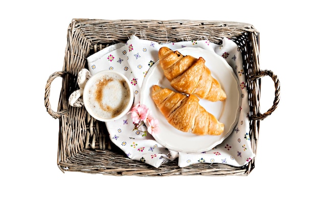 Flor de taza de café croissants en estilo romántico en una bandeja de mimbre aislada