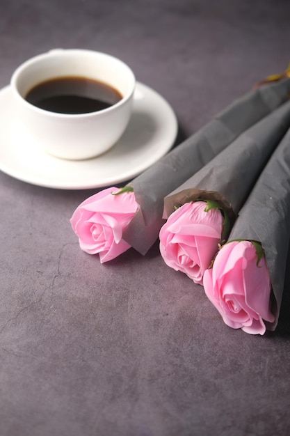 Flor de tulipán de café de composición plana y anteojos sobre fondo negro