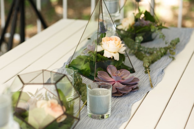 Florarium com suculentas frescas e rosa decoração de mesa festiva.